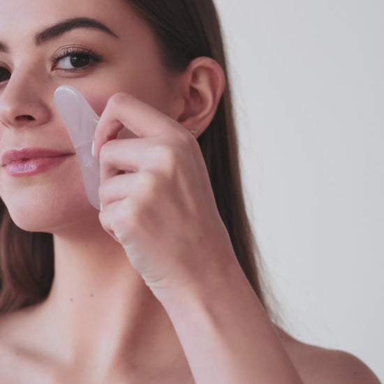 Video of woman using a rose quartz gua sha glow stone